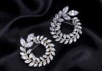 a pair of earrings sitting on top of a black cloth